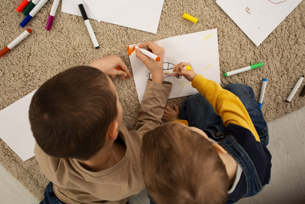 Niños pintando en el suelo con rotuladores de colores