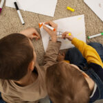 Niños pintando en el suelo con rotuladores de colores